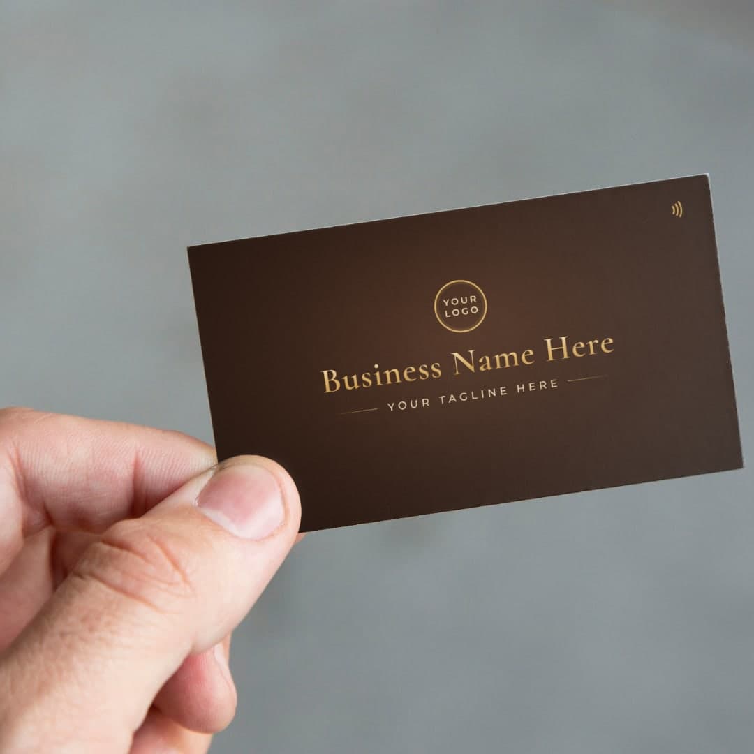 A hand holding a customized card with a business name and logo